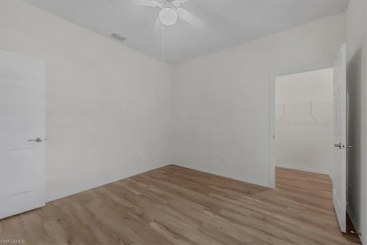 Spare room with light wood finished floors and a ceiling fan