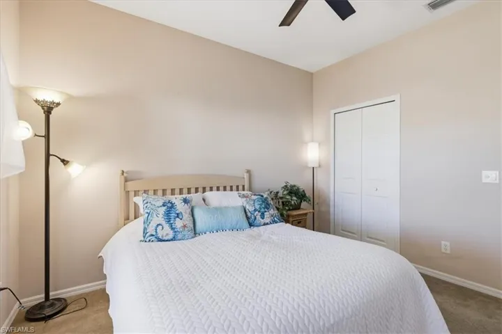 Carpeted bedroom featuring a ceiling fan and a closet