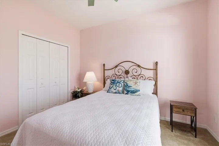 Bedroom with light carpet, a closet, and ceiling fan