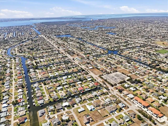 Aerial view of property's location featuring a nearby body of water and nearby suburban area