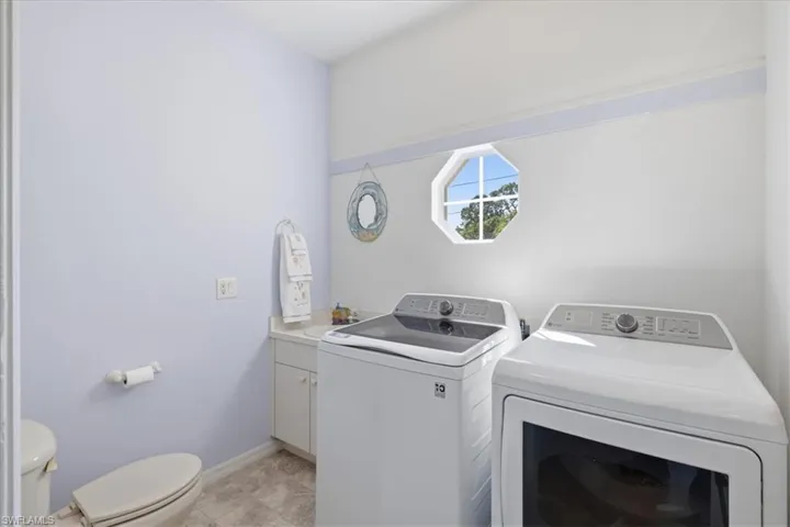 Laundry room featuring independent washer and dryer and baseboards