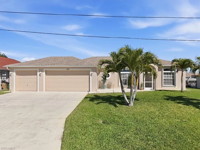 Ranch-style home with attached garage, concrete driveway, front lawn, and stucco siding.