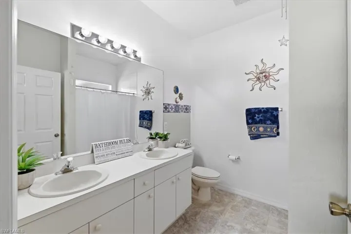 Bathroom with double vanity and curtained shower