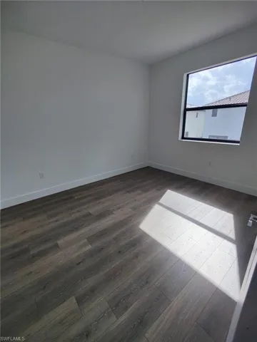 Spare room with dark wood-type flooring