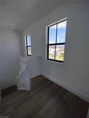 Empty room with dark hardwood / wood-style floors