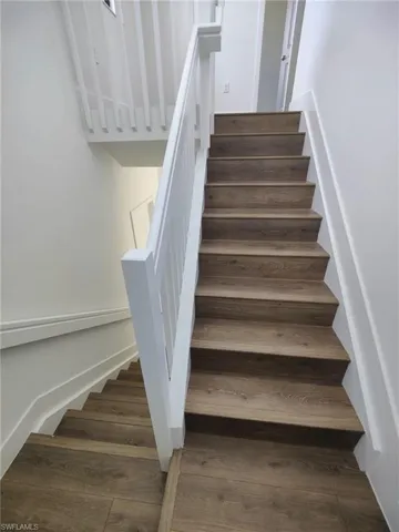 Stairs featuring hardwood / wood-style flooring