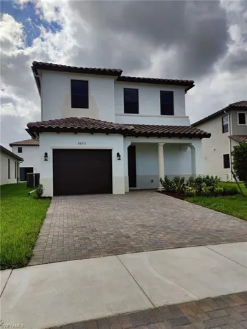 Mediterranean / spanish-style house featuring a front lawn, a garage, and central AC