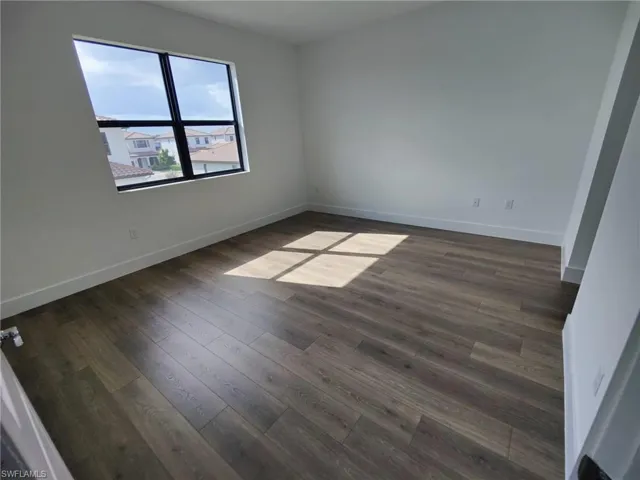 Unfurnished room featuring dark wood-type flooring