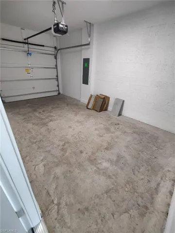 Garage featuring electric panel and a garage door opener