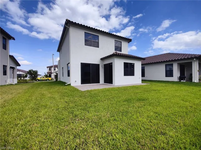 Rear view of property with a yard and a patio area