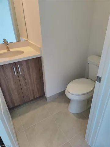 Bathroom featuring tile patterned flooring, vanity, and toilet