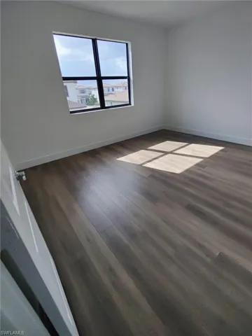 Empty room featuring dark wood-type flooring