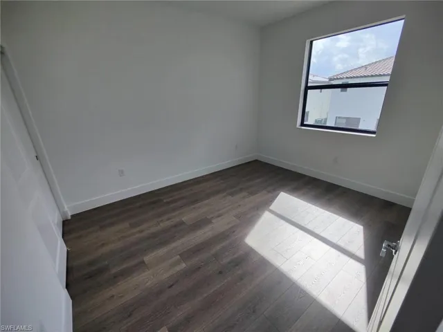 Empty room featuring dark wood-type flooring