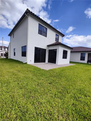 Back of property with a yard and a patio