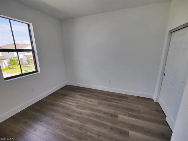 Unfurnished room featuring dark hardwood / wood-style flooring