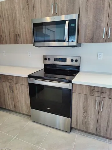 Kitchen featuring appliances with stainless steel finishes and light tile patterned floors