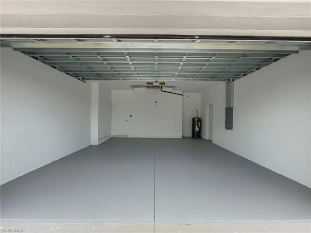 Garage featuring electric panel and water heater