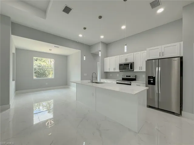 Kitchen featuring baseboards, visible vents, appliances with stainless steel finishes, and a sink