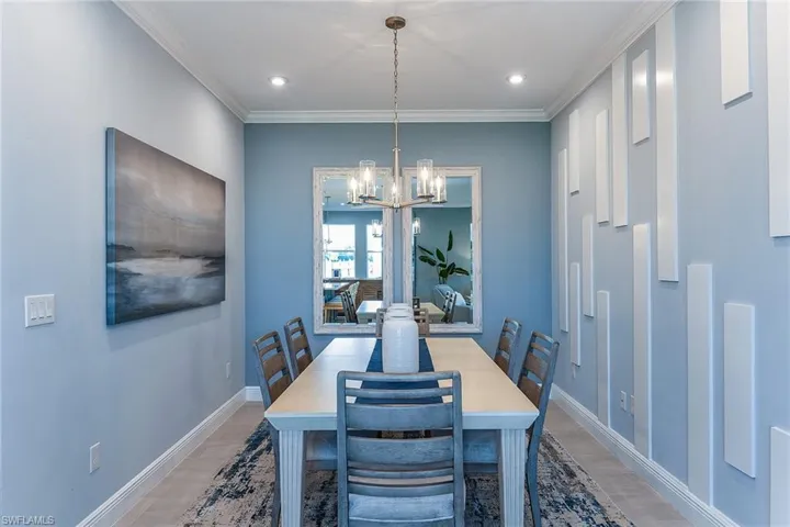 Dining room featuring a chandelier, wood finished floors, crown molding, and recessed lighting