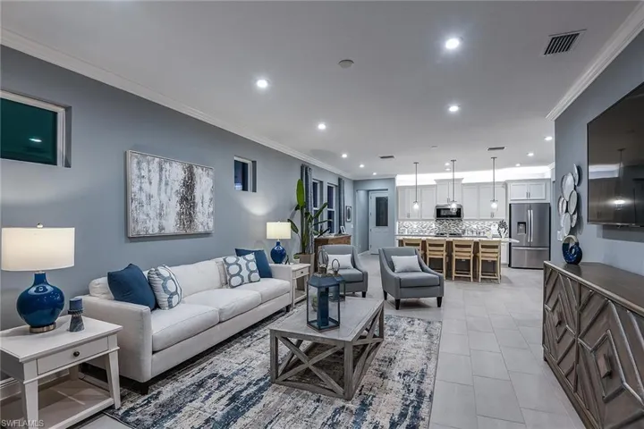 Living room with crown molding, light tile patterned floors, and recessed lighting