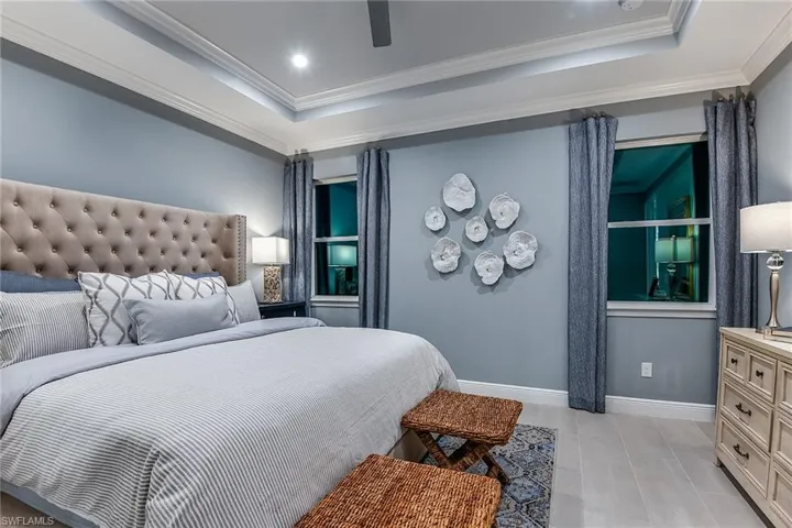 Bedroom with ornamental molding, a raised ceiling, ceiling fan, recessed lighting, and light tile patterned floors