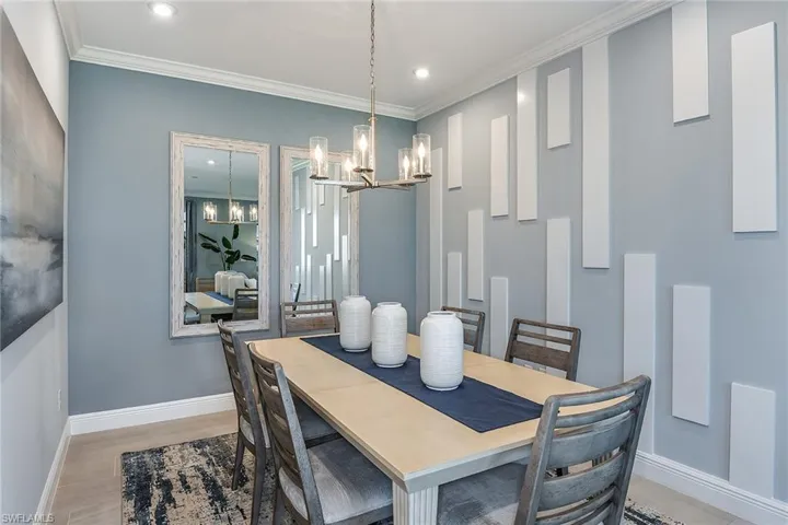 Dining space with crown molding, a chandelier, recessed lighting, and light wood-style flooring