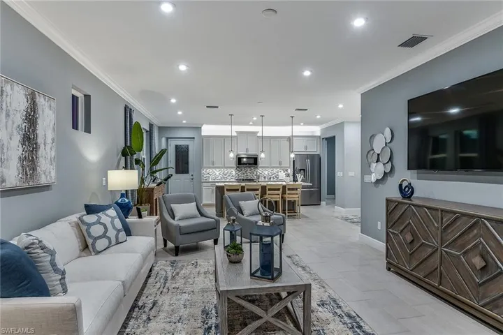 Living area with crown molding and recessed lighting