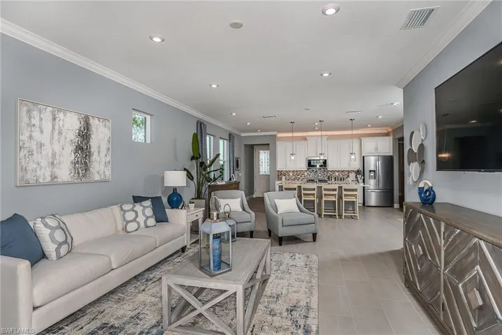 Living area featuring crown molding, recessed lighting, and light tile patterned flooring
