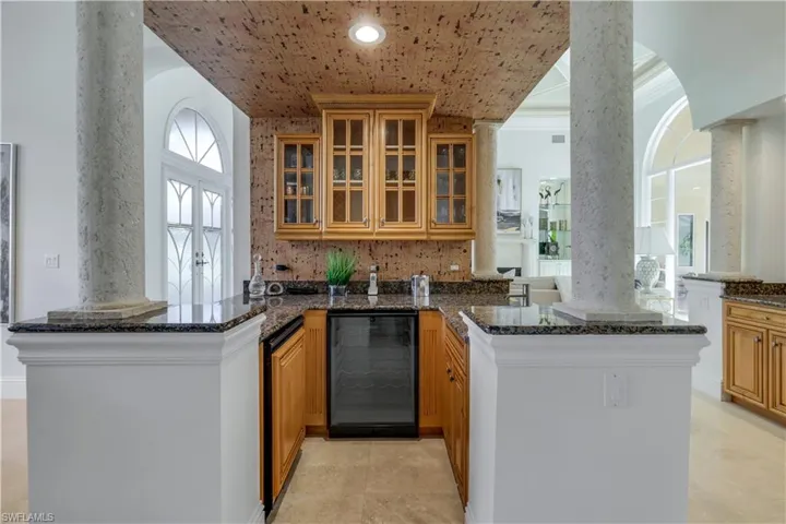 Walk-in wet bar has glass display cabinets, refrigerator, wine cooler & sink plus built-in wine rack and centers around dining room, living area plus kitchen areas. To the right is a breakfast buffet area!