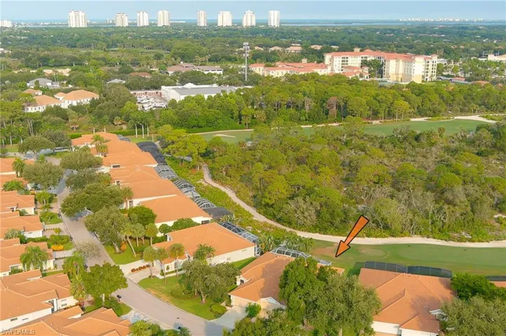 Residential property featuring terracotta-tiled roofs, mature landscaping, golf course frontage, and a surrounding natural environment