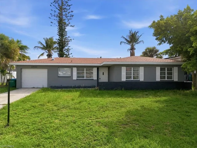 Single-story residence featuring a gray exterior, white window shutters, and an attached garage