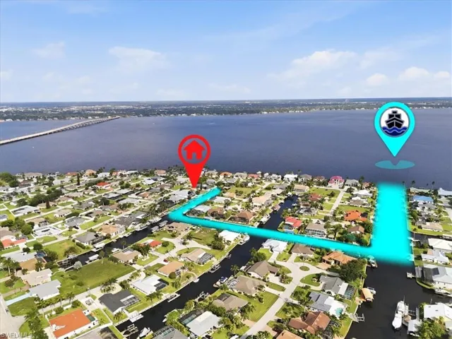Aerial perspective showcasing a waterfront community with direct canal access leading to open water