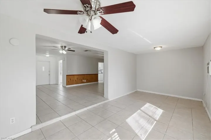 Open-concept living area featuring light gray walls and tile flooring