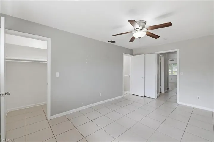 Spacious room featuring light gray walls and white tile flooring