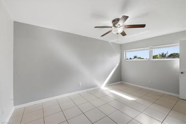Room featuring light gray walls, white ceiling, and tiled flooring