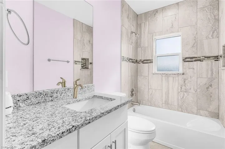 Full bath featuring vanity and washtub / shower combination
