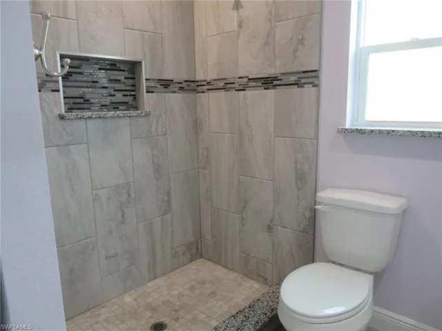 Full bath with a stall shower and toilet