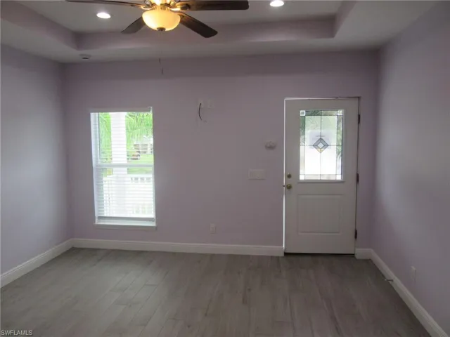 Entrance foyer featuring a tray ceiling, light wood-type flooring, ceiling fan, and recessed lighting