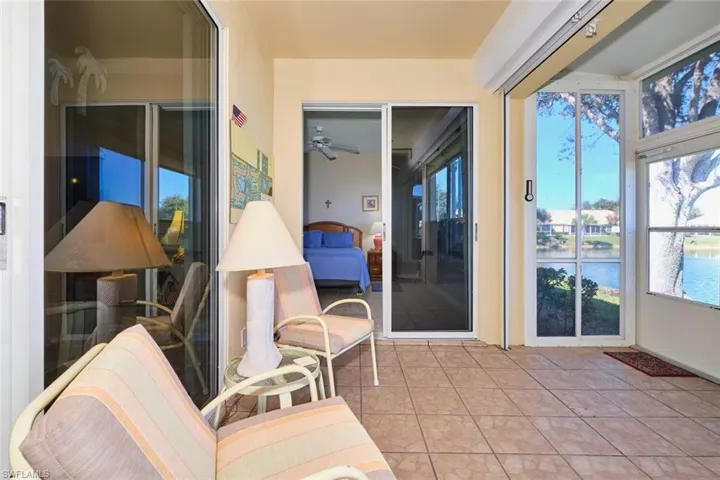 Sunroom featuring tile patterned flooring and a water view