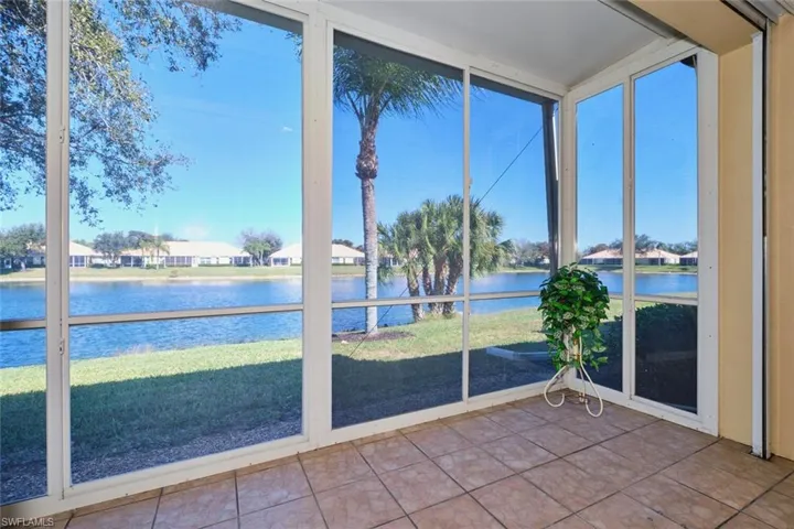 Unfurnished sunroom featuring a residential view and a water view