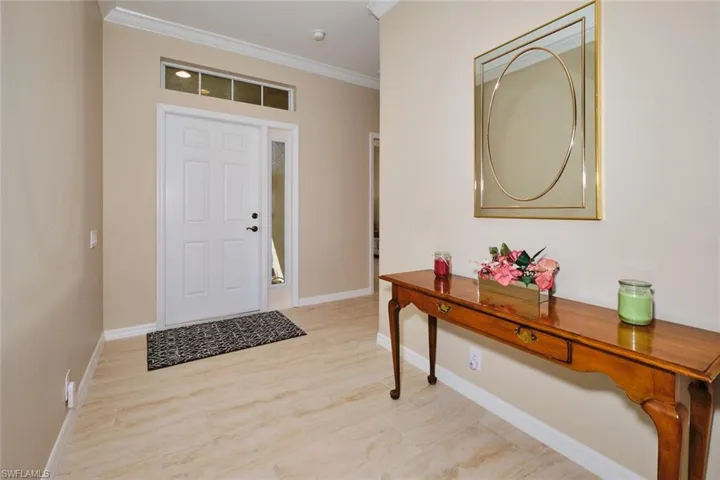 Entryway featuring ornamental molding and light wood-style floors