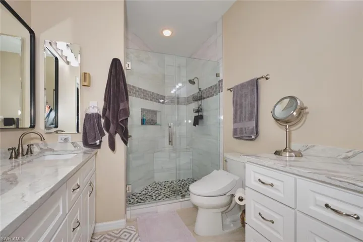Full bath featuring vanity, a stall shower, and light tile patterned floors