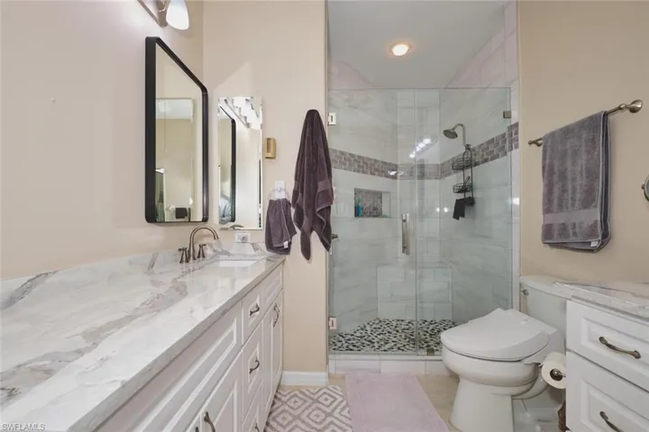 Bathroom with vanity, a shower stall, and light tile patterned flooring