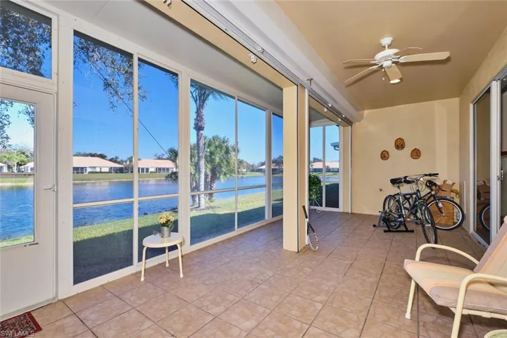 Sunroom featuring tile patterned flooring and a water view