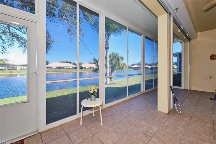 Sunroom / solarium with floor to ceiling windows, tile patterned flooring, and a water view