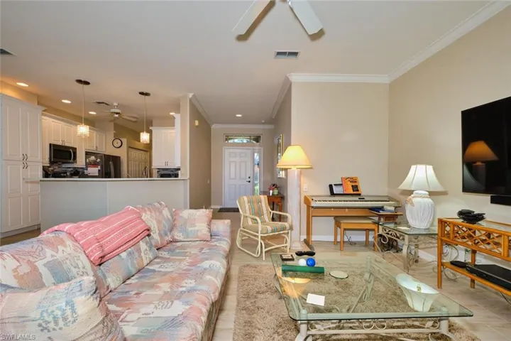Living room with ceiling fan and ornamental molding