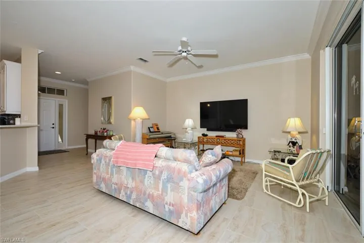 Living area with crown molding and a ceiling fan