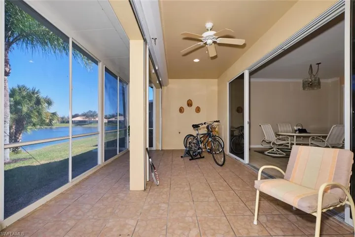 Sunroom featuring a ceiling fan, a water view, and healthy amount of natural light