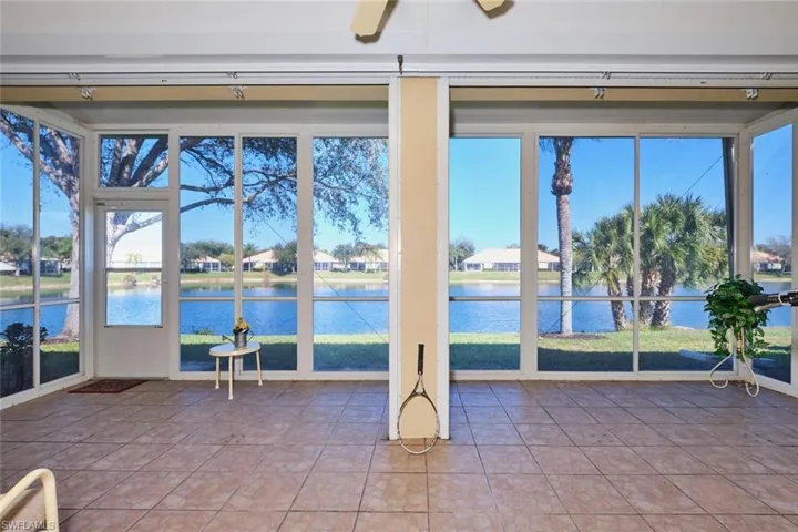Unfurnished sunroom with healthy amount of natural light, tile patterned flooring, and a water view