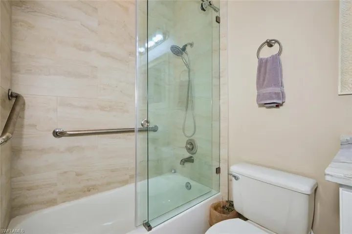 Full bathroom with combined bath / shower with glass door and vanity